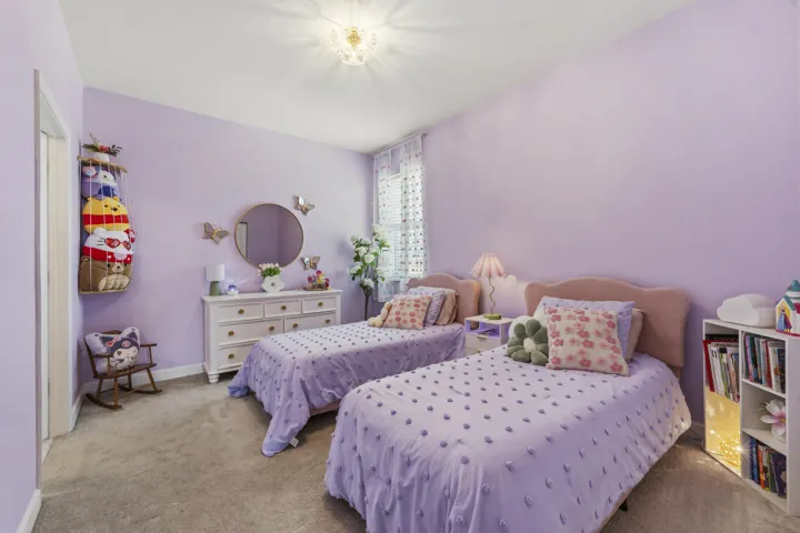 This generously sized bedroom offers plenty of natural light, ample space for multiple beds or furniture, and a comfortable retreat for family or guests.