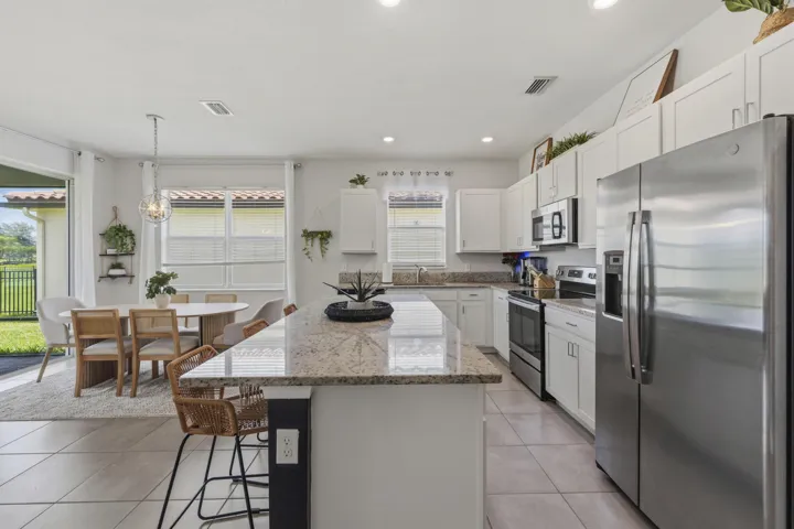 The heart of the home features granite countertops, stainless steel appliances, abundant cabinetry, and a large center island.