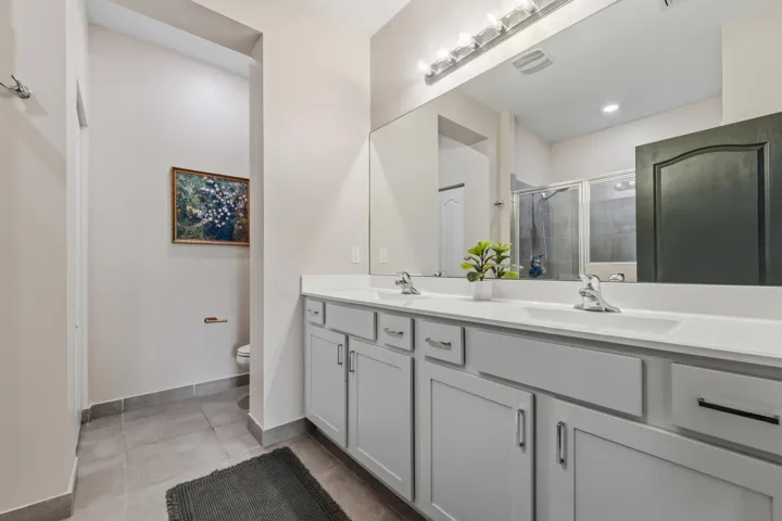 Enjoy a luxurious owner's bath featuring dual sinks, a large vanity, abundant storage, and a spacious walk-in shower.
