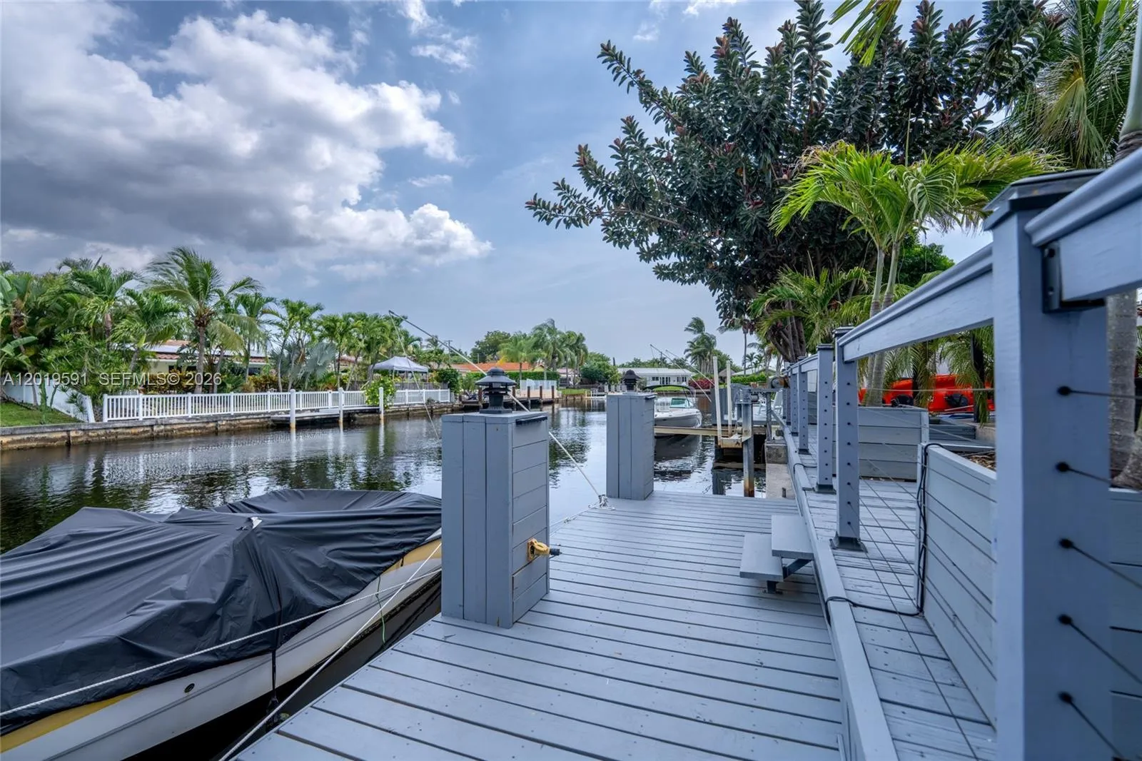 Private waterfront dock with direct canal access, tropical scenery, and South Florida boating lifestyle.