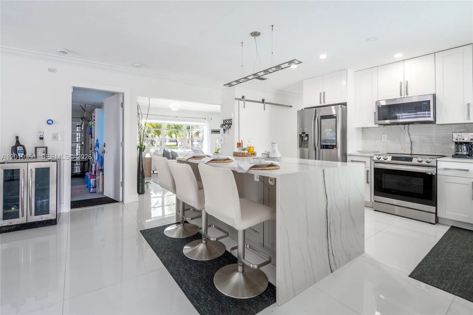 Elegant contemporary kitchen with bar seating, premium appliances, and stylish South Florida ambiance.