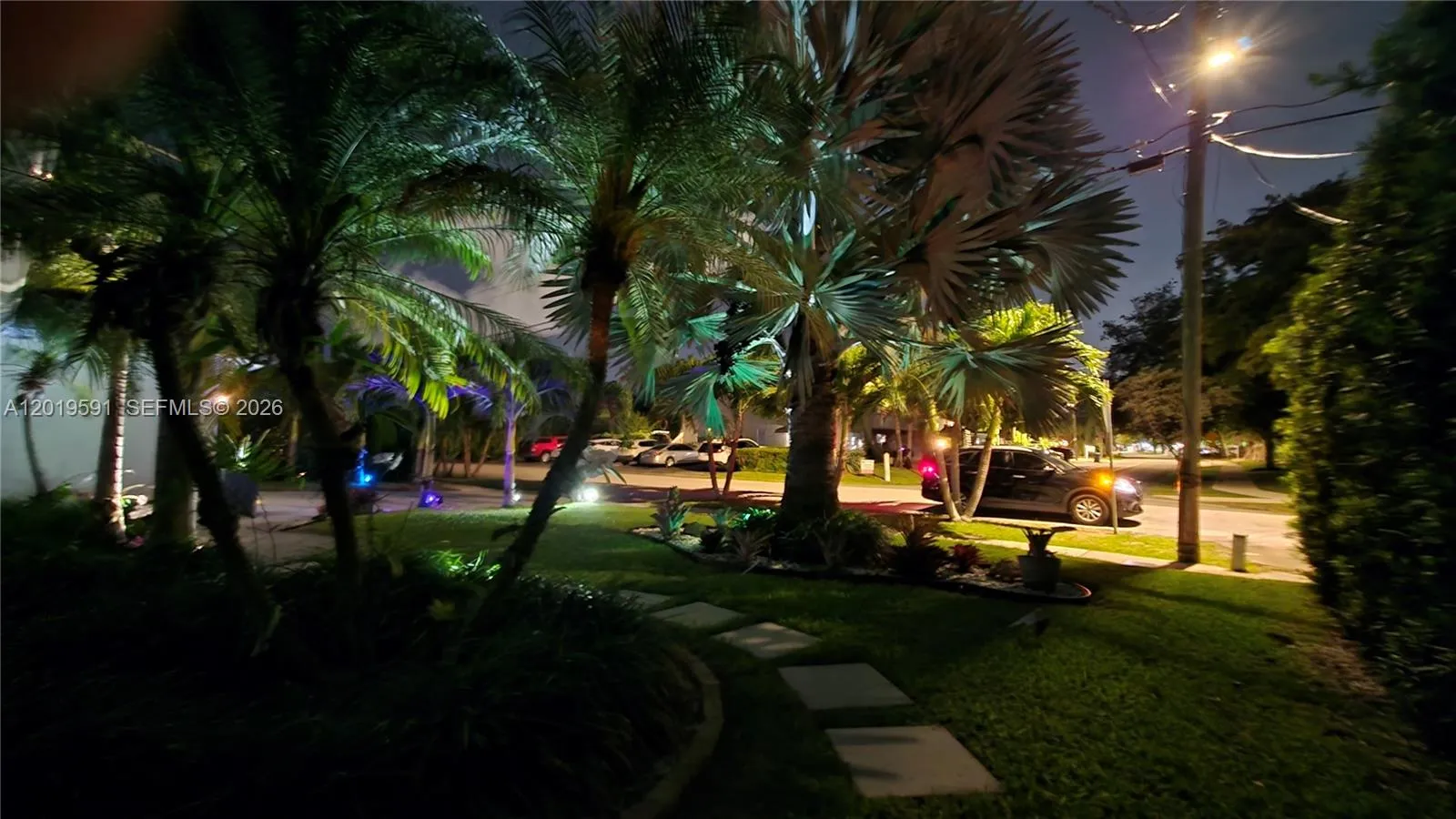 Beautiful tropical community surroundings with illuminated palm trees and relaxing South Florida evening atmosphere.