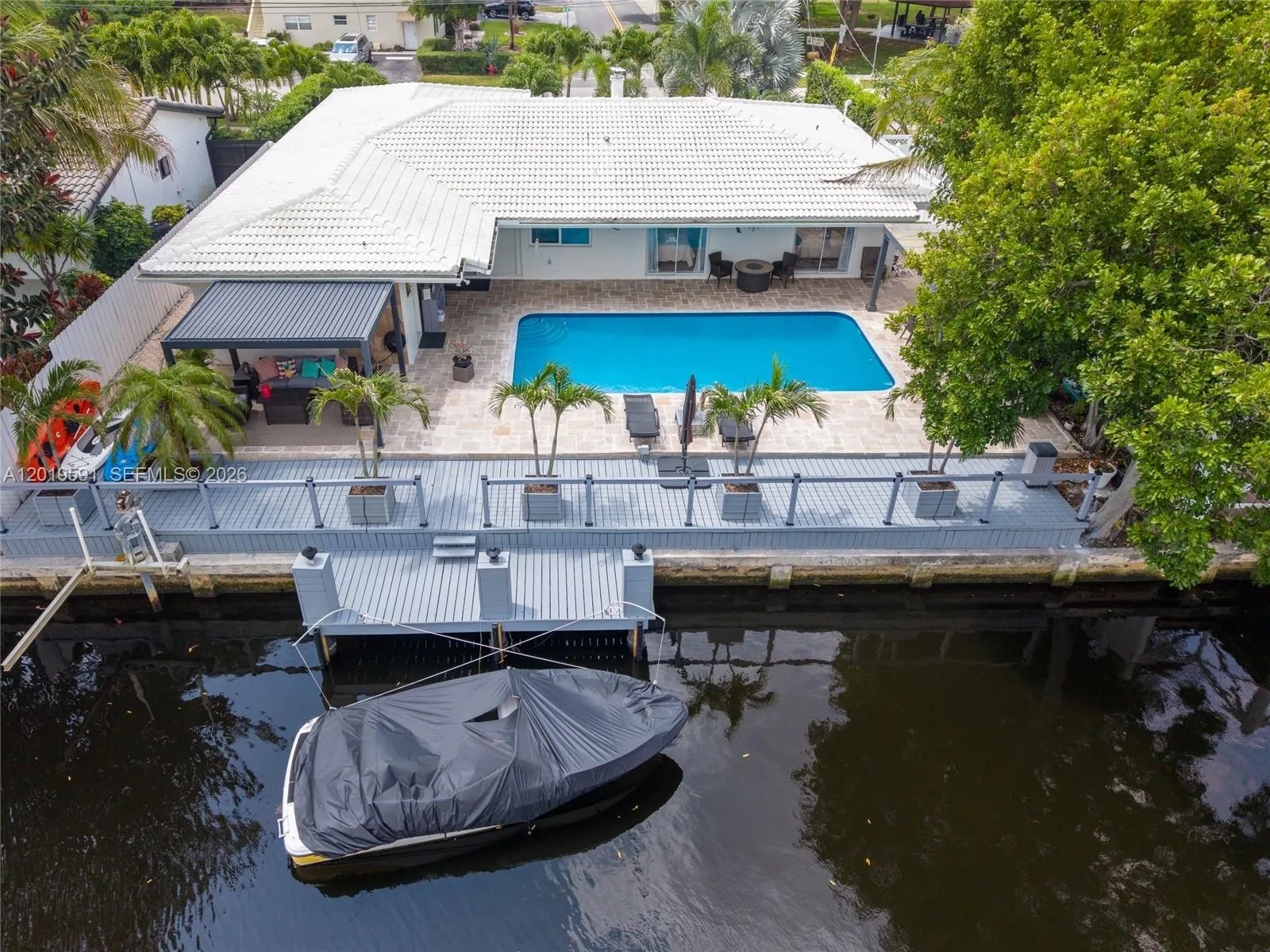 Private waterfront backyard with dock, heated pool, and resort-style South Florida outdoor living.