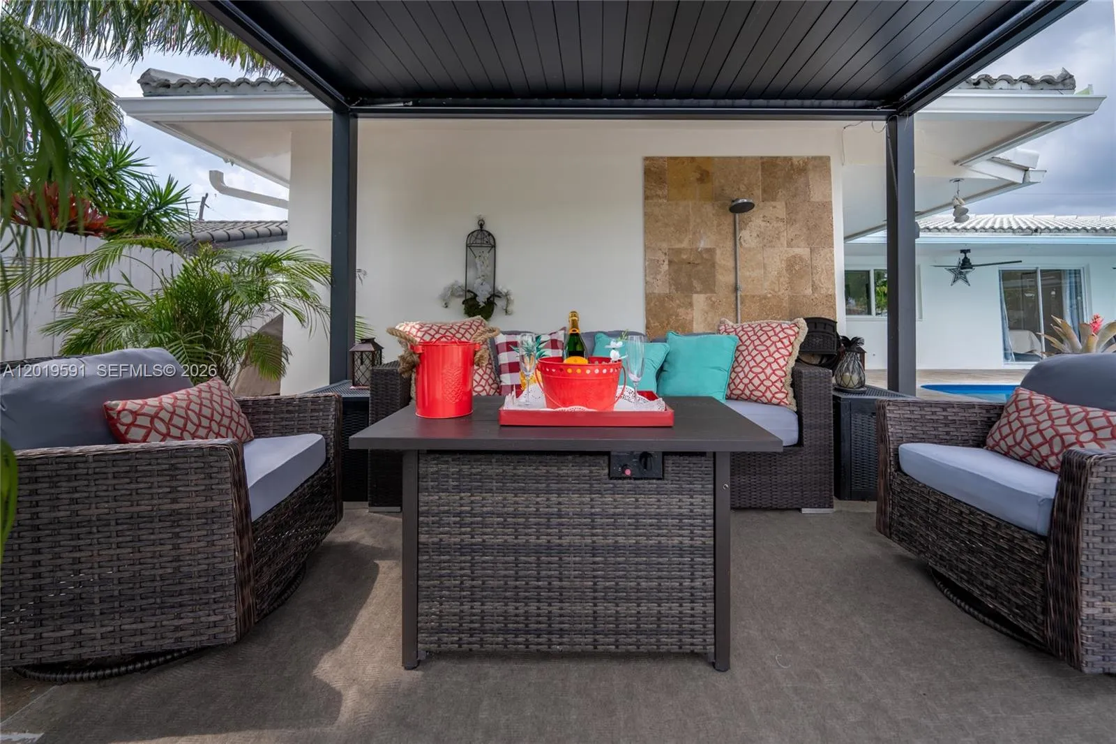 Elegant covered patio with luxury outdoor seating, waterfront views, and tropical South Florida ambiance.