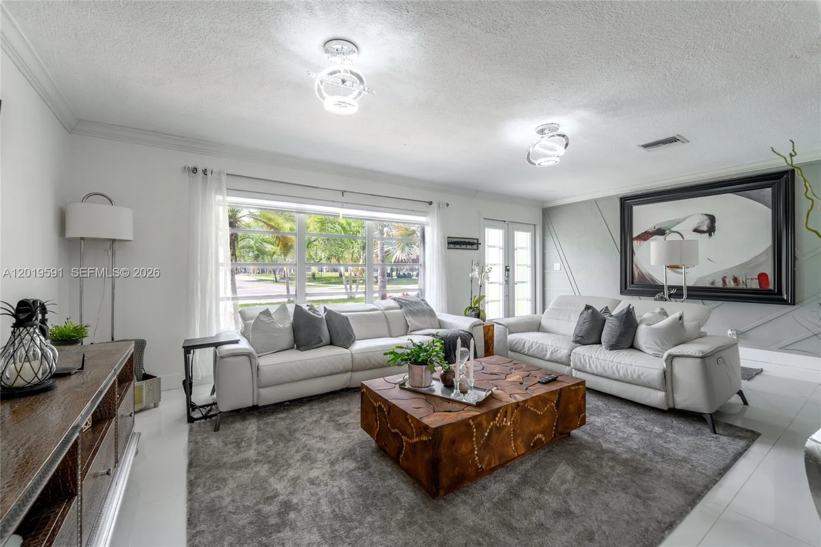 Spacious luxury living room with poolside views, stylish furnishings, and relaxing South Florida atmosphere.
