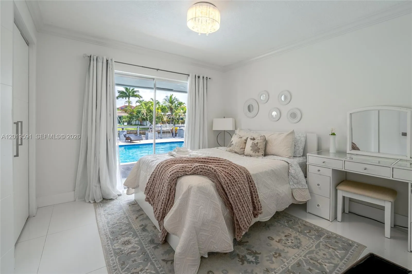 Stylish guest bedroom featuring cozy accommodations, poolside views, and bright contemporary design.