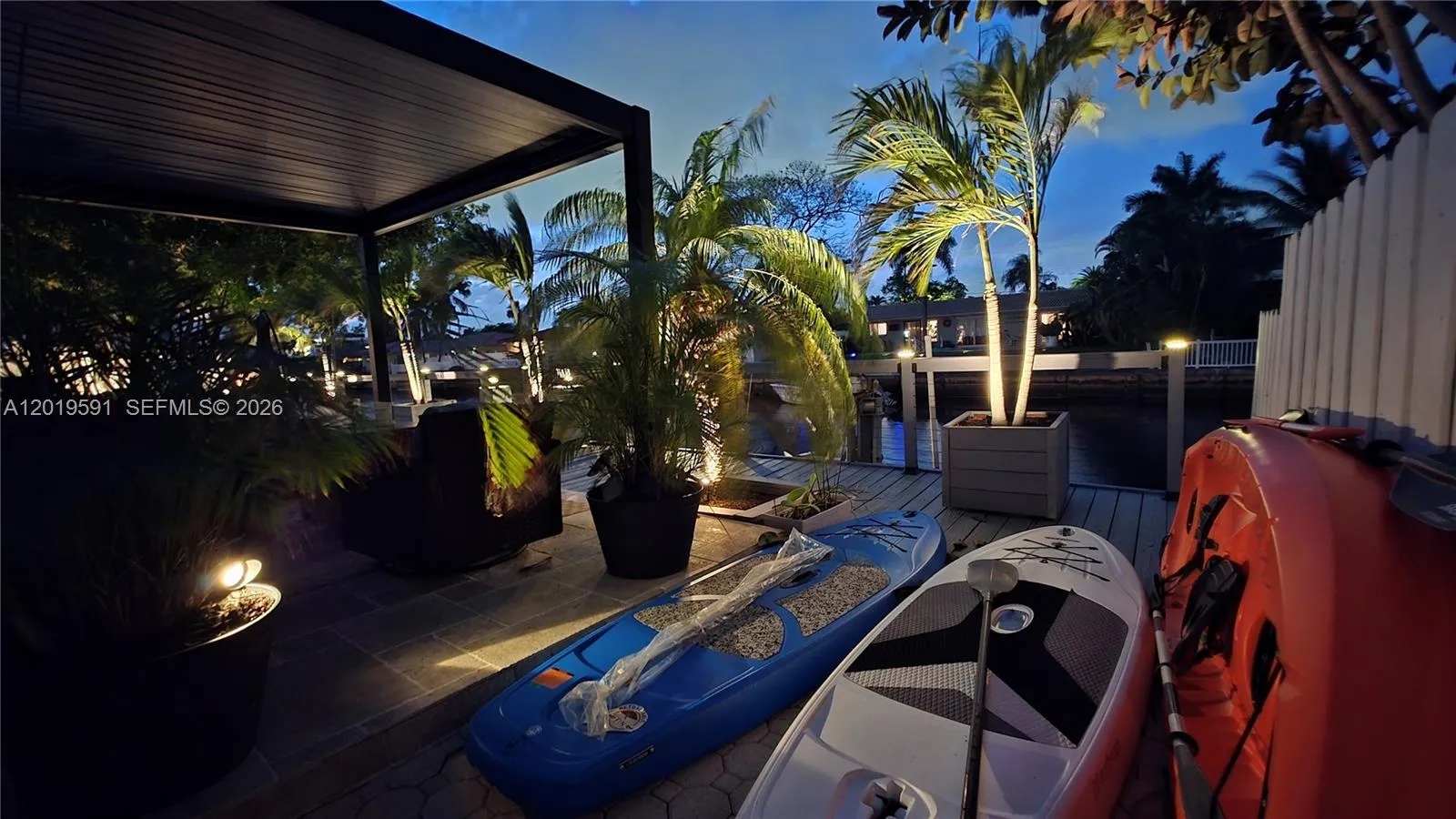 Tropical waterfront patio at sunset with luxury outdoor seating and relaxing South Florida ambiance.