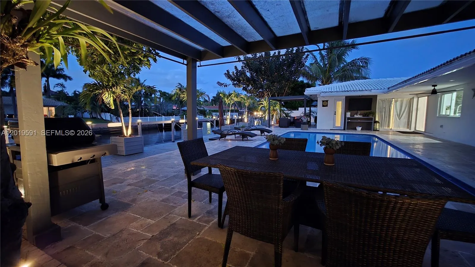 Elegant evening patio with waterfront ambiance, outdoor dining space, and luxury resort-style atmosphere.