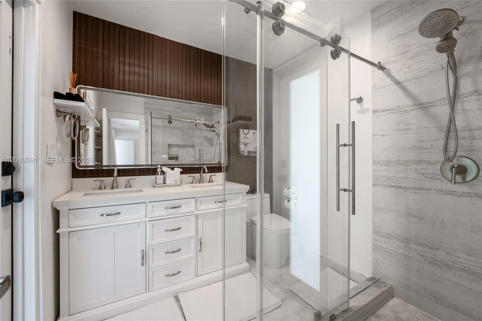 Modern spa-inspired bathroom with walk-in glass shower, double vanity, and upscale finishes.