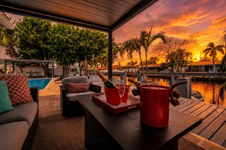 Covered waterfront patio with sunset views, outdoor lounge seating, and relaxing luxury vacation atmosphere.