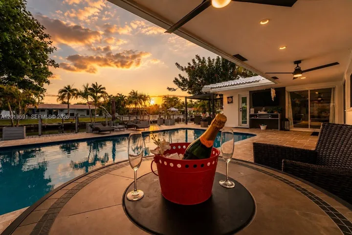 Luxury waterfront pool oasis at sunset with resort-style outdoor living and tropical South Florida ambiance.