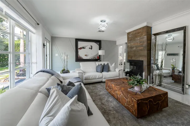 Bright modern living room with open-concept design, elegant finishes, and poolside natural light.