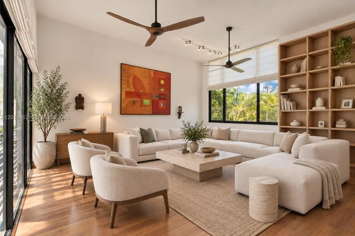 Living area featuring floor-to-ceiling windows with black frames, built-in floor-to-ceiling shelving, wood-finish flooring, and dual ceiling fans