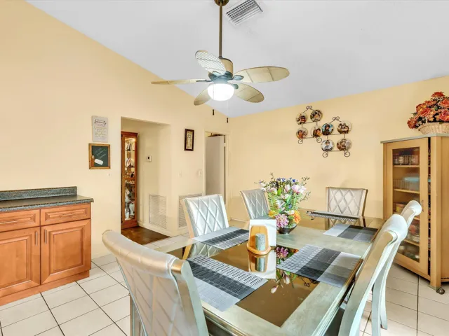 Dining space with kitchen access, tile flooring, ceiling fan, and natural light for everyday meals and entertaining.