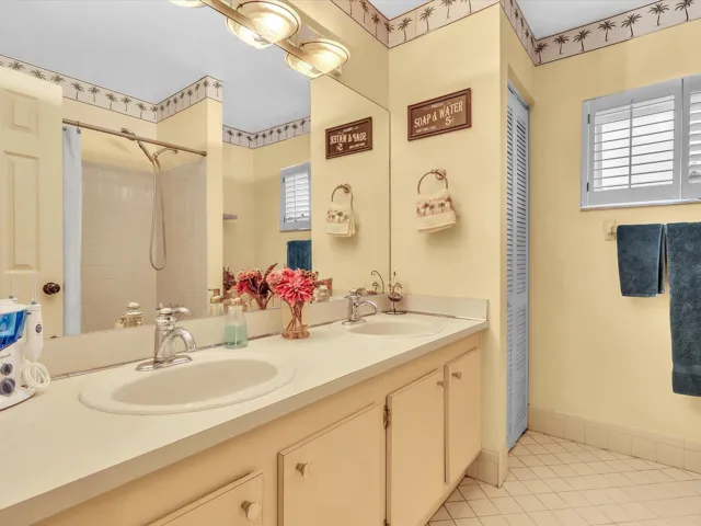 Second bathroom with vanity, mirror, tile flooring, and shower area in this 3-bedroom, 2-bath Lauderhill home.