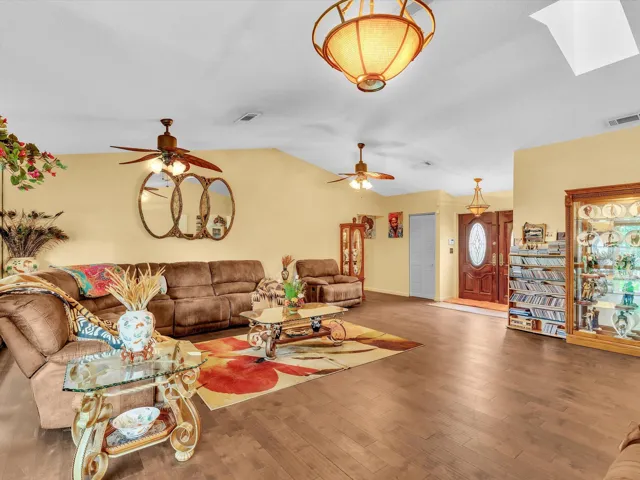 Living room view toward the front entry showing open interior flow, seating space, and natural light throughout the main area.