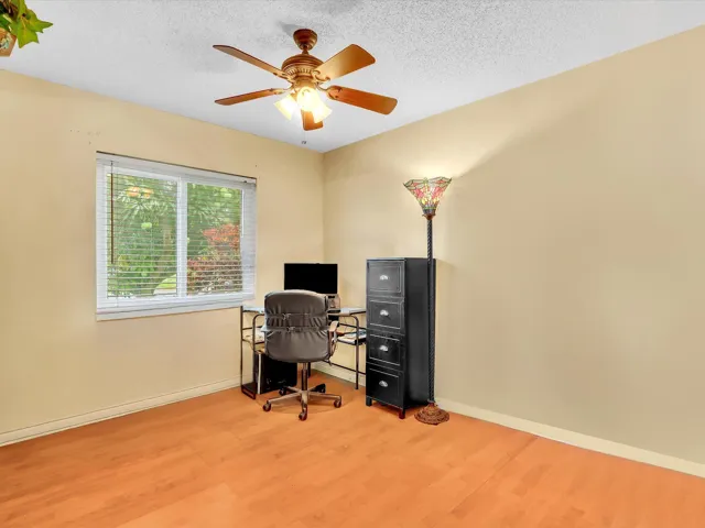 Bedroom 3 with wood-look flooring, ceiling fan, window, and flexible space for a bedroom, office, or guest room.