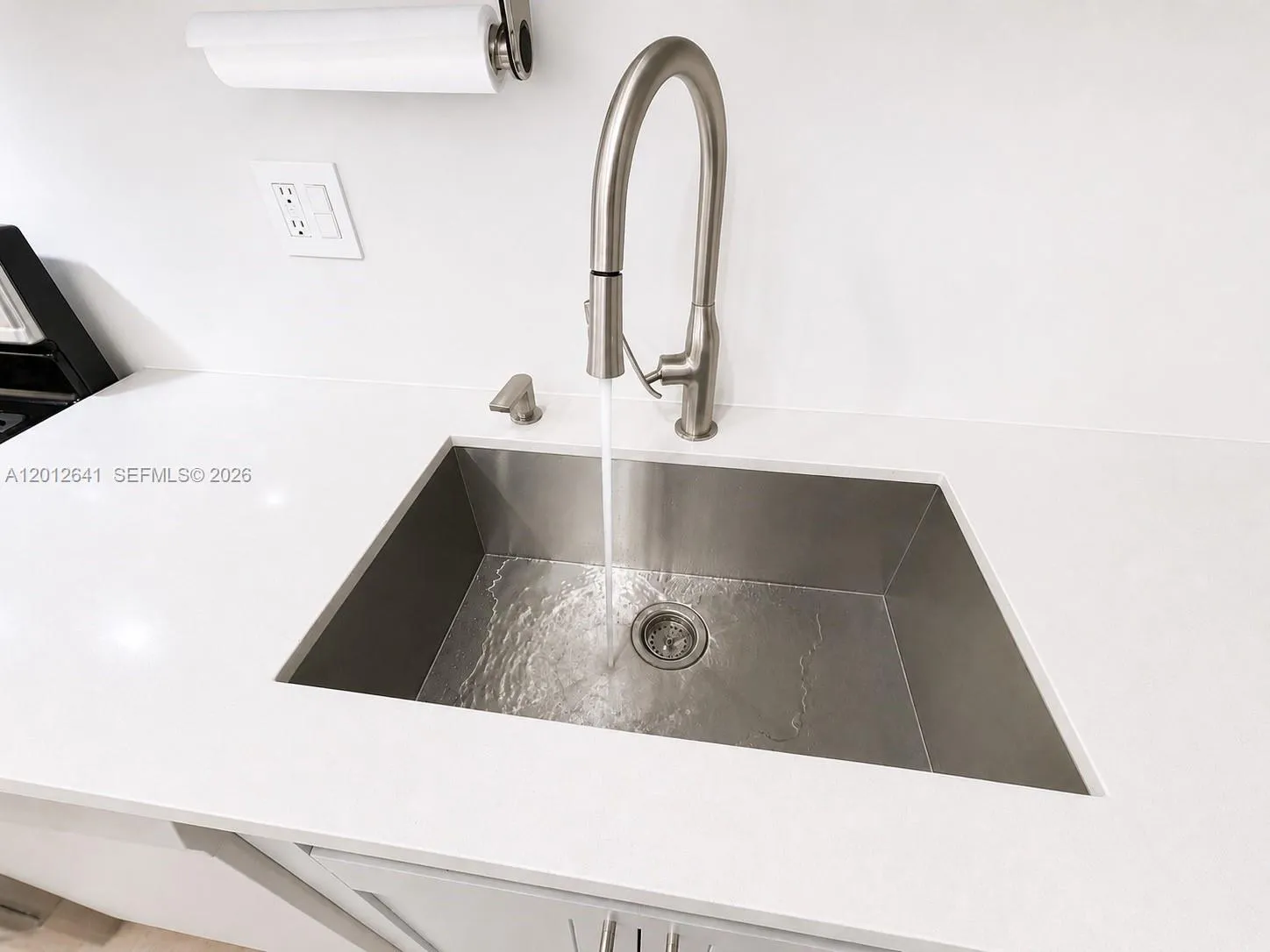 CUSTOM DESIGNED QUARTZ COUNTER WITH UNDERMOUNTED STAINLESS STEEL COMMERCIAL SINK