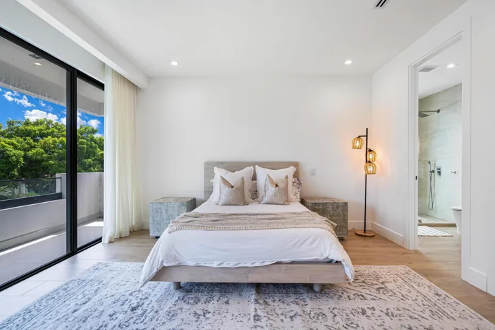 Generous east-facing bedroom filled with natural light and private balcony access.