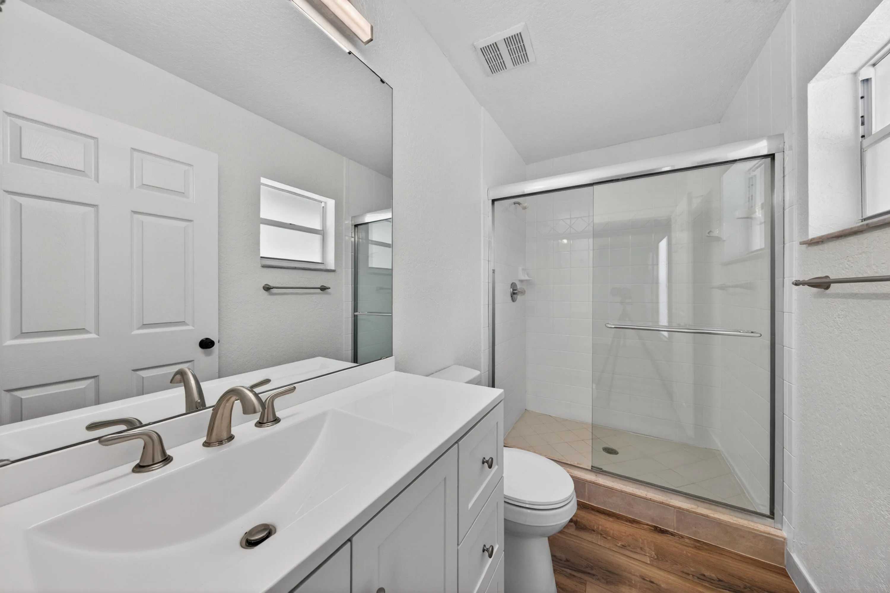 Primary bathroom with a glass-enclosed shower and modern vanity