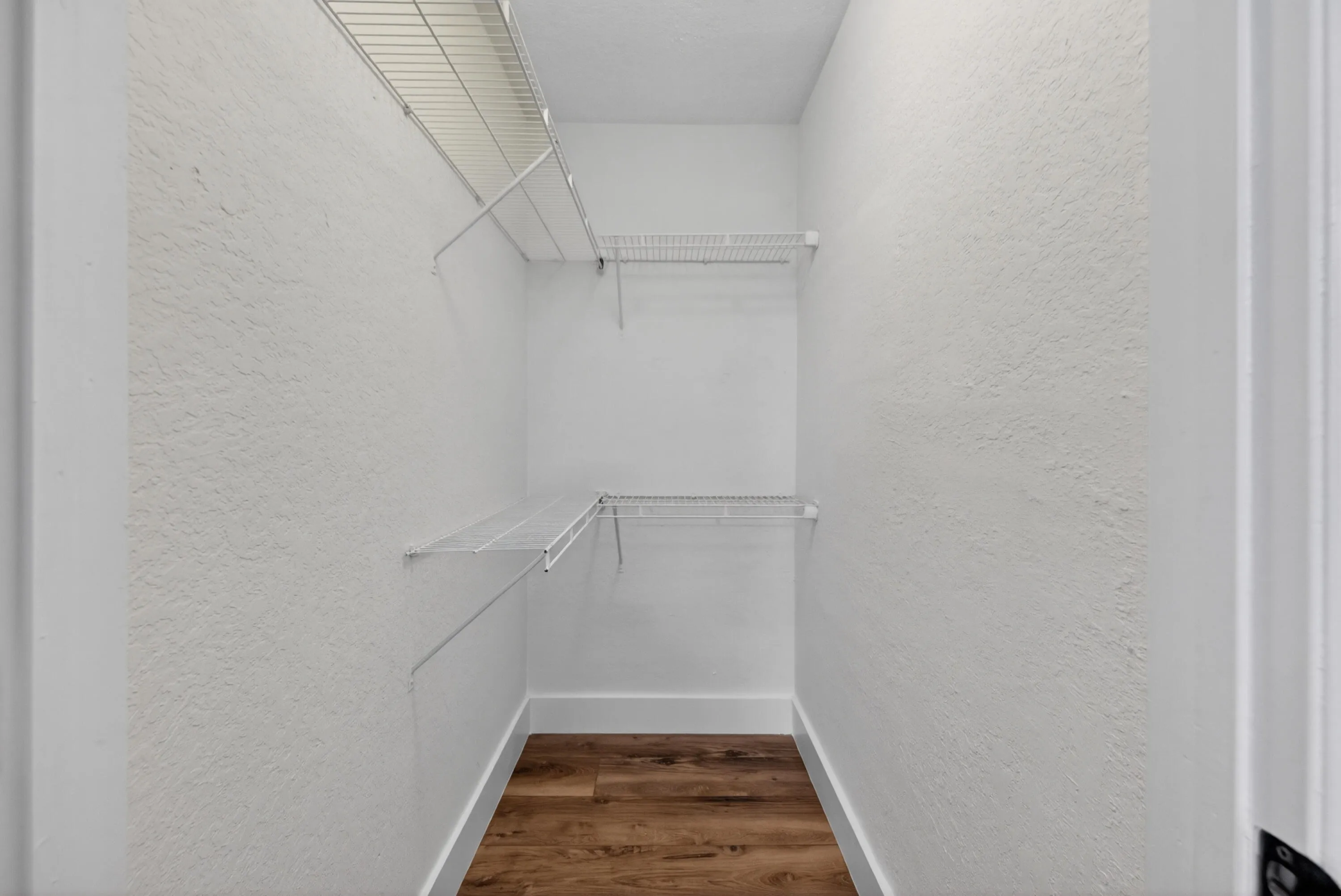 Walk-in closet offering practical built-in shelving and ample storage space.