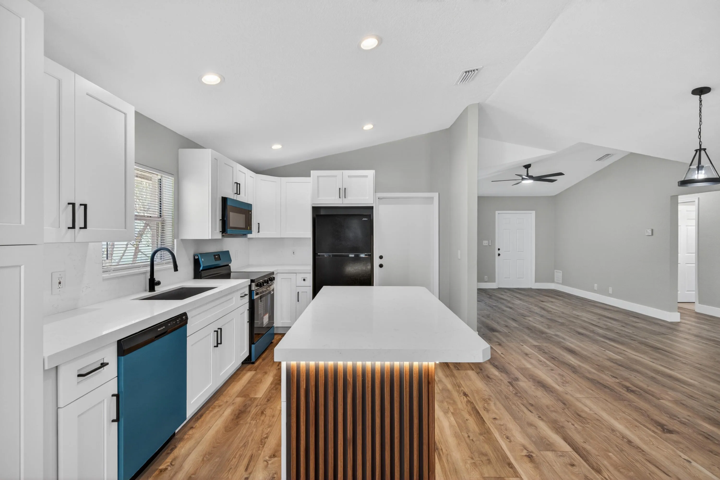 Open kitchen featuring modern cabinetry, quartz countertops, and a center island