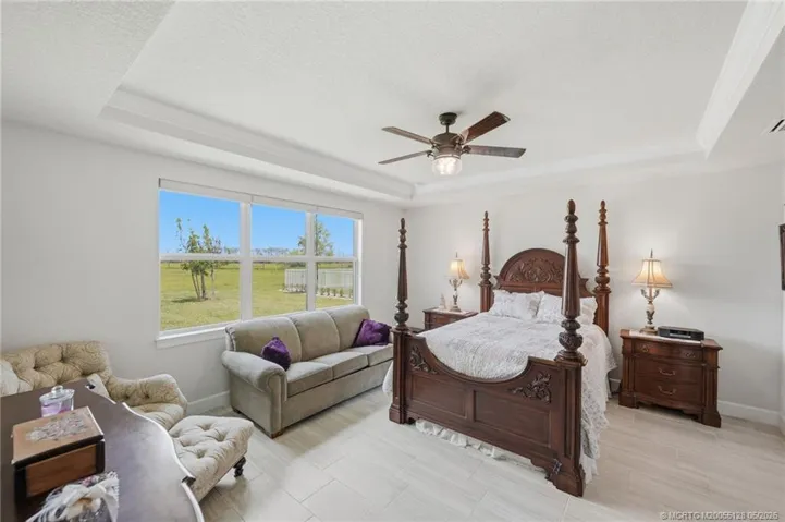 Private guest suite offers a spacious and comfortable retreat with elegant tray ceiling detail, abundant natural light, and peaceful preserve views. Perfect for extended family or overnight visitors, this inviting suite provides comfort, privacy, and a relaxing coastal atmosphere.