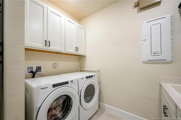 Spacious laundry room offers abundant storage with upgraded cabinetry, utility sink, and convenient workspace for everyday functionality. Thoughtfully designed with modern finishes and plenty of room for organization and household tasks.
