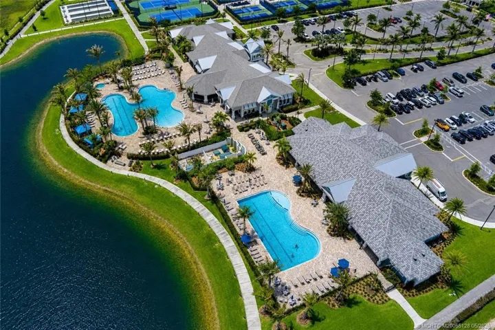 Spectacular aerial view of the Del Webb at Tradition amenity campus showcases resort-style pools and spa, beautifully designed clubhouse facilities, lakeside walking paths, tennis and pickleball courts, and exceptional recreational amenities that define the active Florida lifestyle.