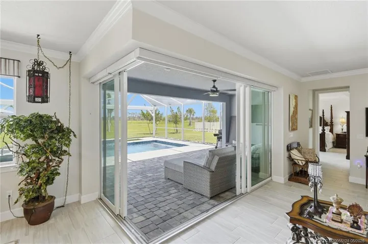 Expansive corner sliding glass doors create a seamless transition between indoor and outdoor living spaces, opening to a covered lanai, screened pool, and peaceful preserve views. This exceptional design fills the home with natural light and provides the perfect setting for entertaining or relaxing in true Florida style.