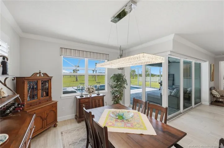 Elegant dining area is perfectly positioned to capture beautiful pool and preserve views through expansive windows and sliding glass doors. Ideal for both casual meals and formal entertaining, this bright and inviting space offers seamless access to the outdoor living area for true Florida indoor-outdoor living.