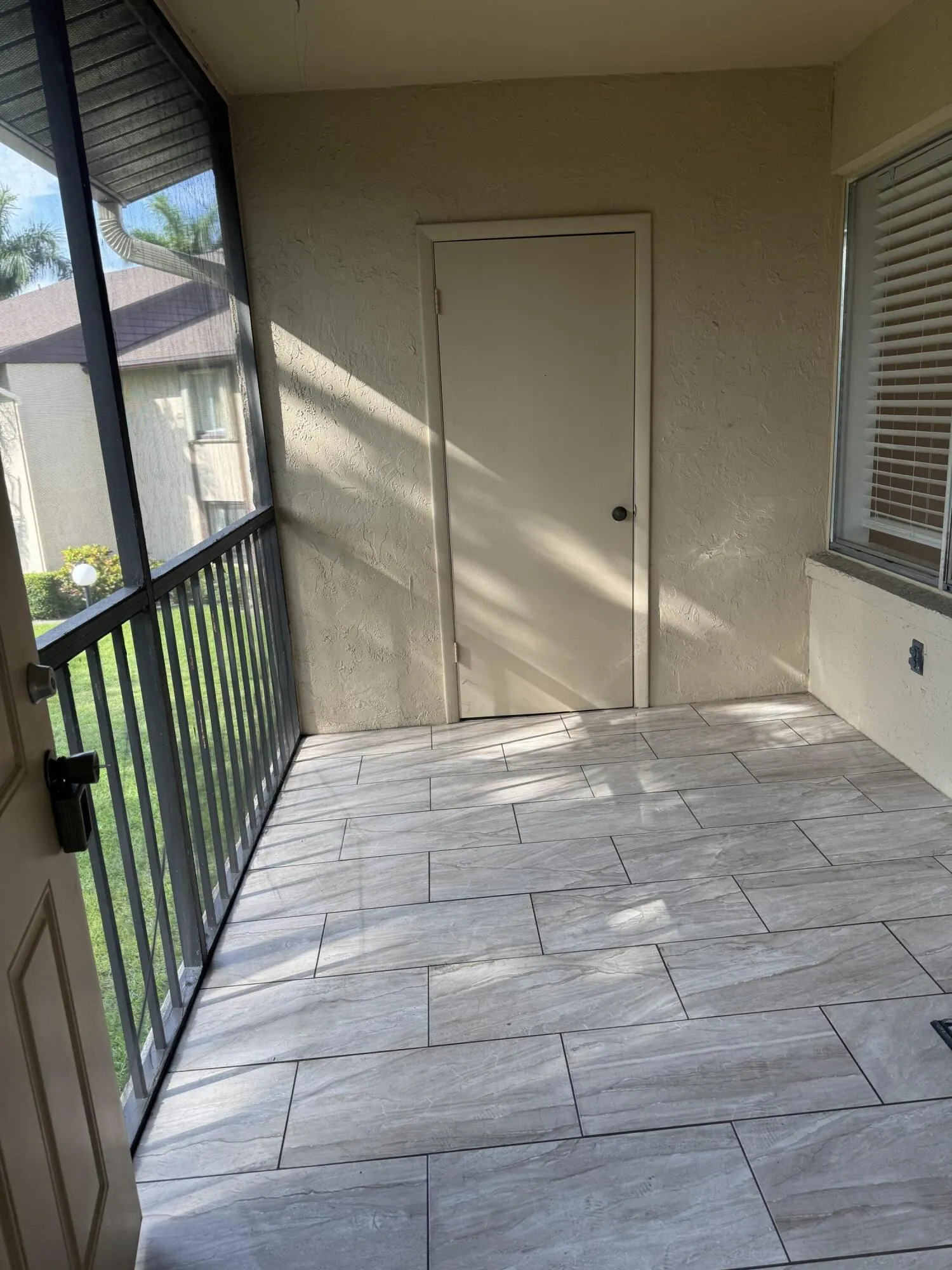 Tiled screened patio with entrance and storage