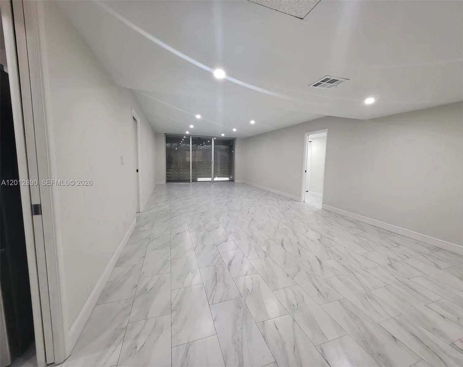 Open concept living and dining room (impact shutters on patio)