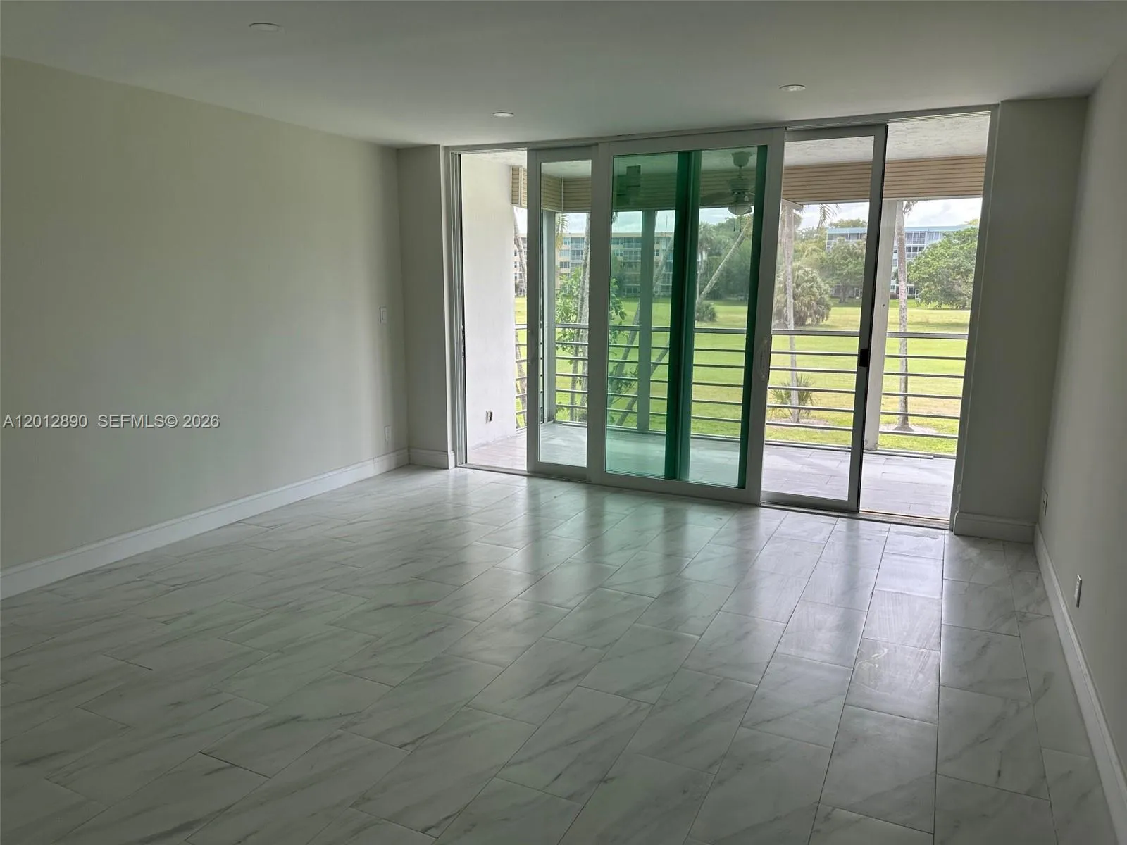 Large living room opening to private terrace and view of golf course