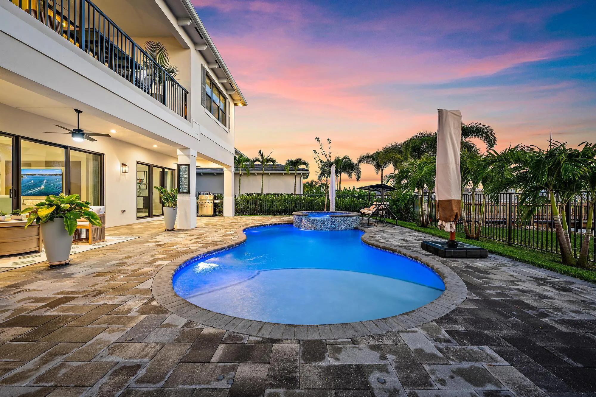Extended pool deck, spa, and waterfall feature.