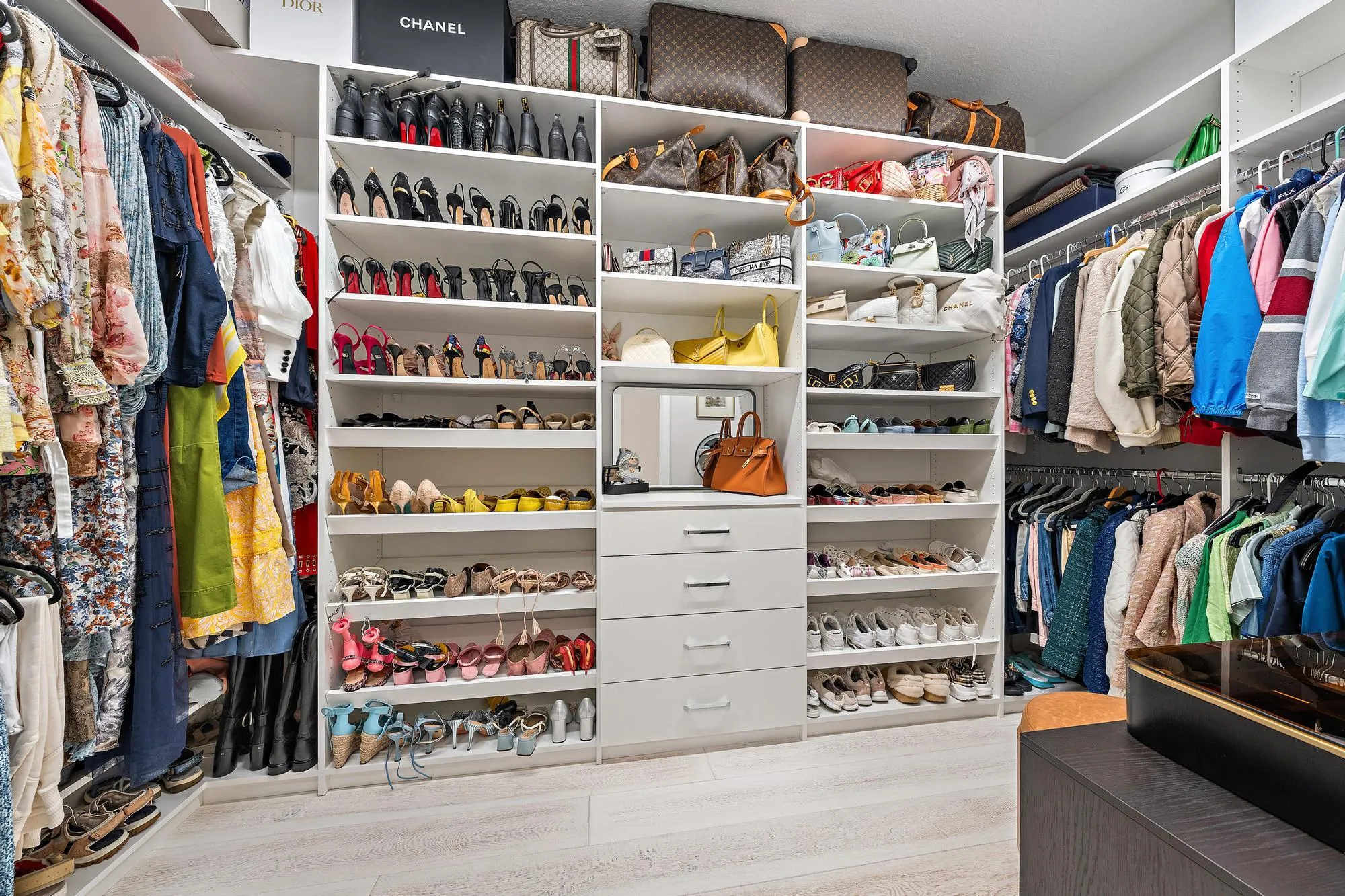Custom closet built-ins with shelving, drawers, and chrome hardware.
