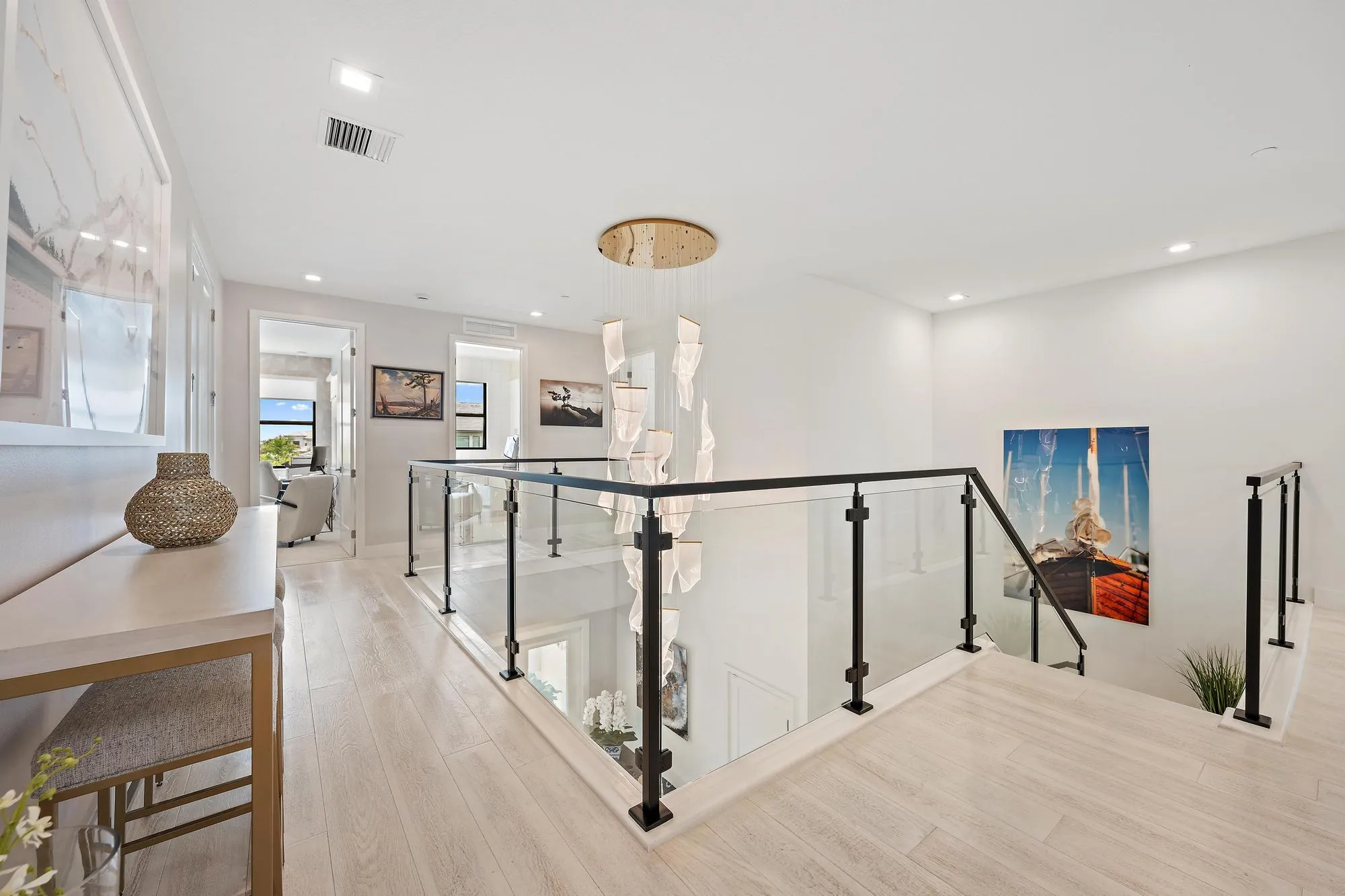 Custom lighting, high-end glass stair railing, and upgraded wood flooring.