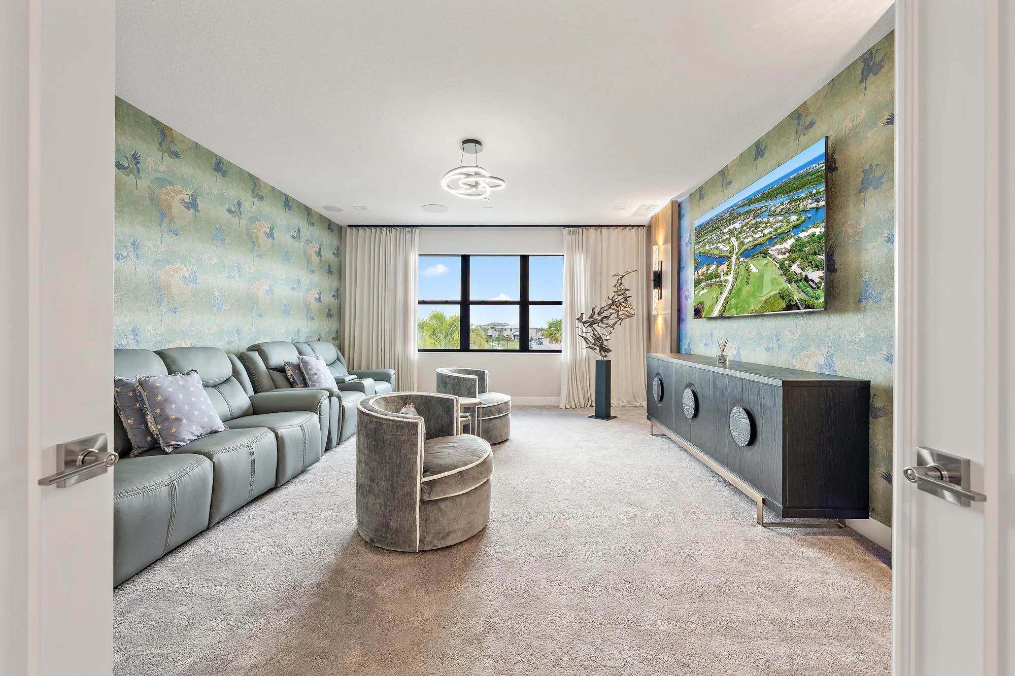 Large 16' x 18' home theater with designer wallpaper and curtains.