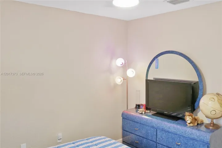 Neutral interior room featuring smooth-finished walls and a circular flush-mount ceiling light fixture