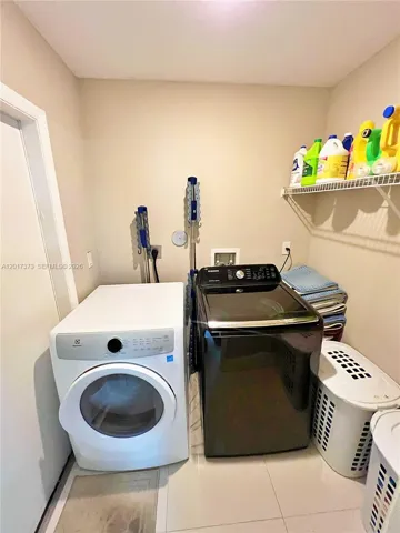 Laundry area featuring tile flooring and open wire shelving