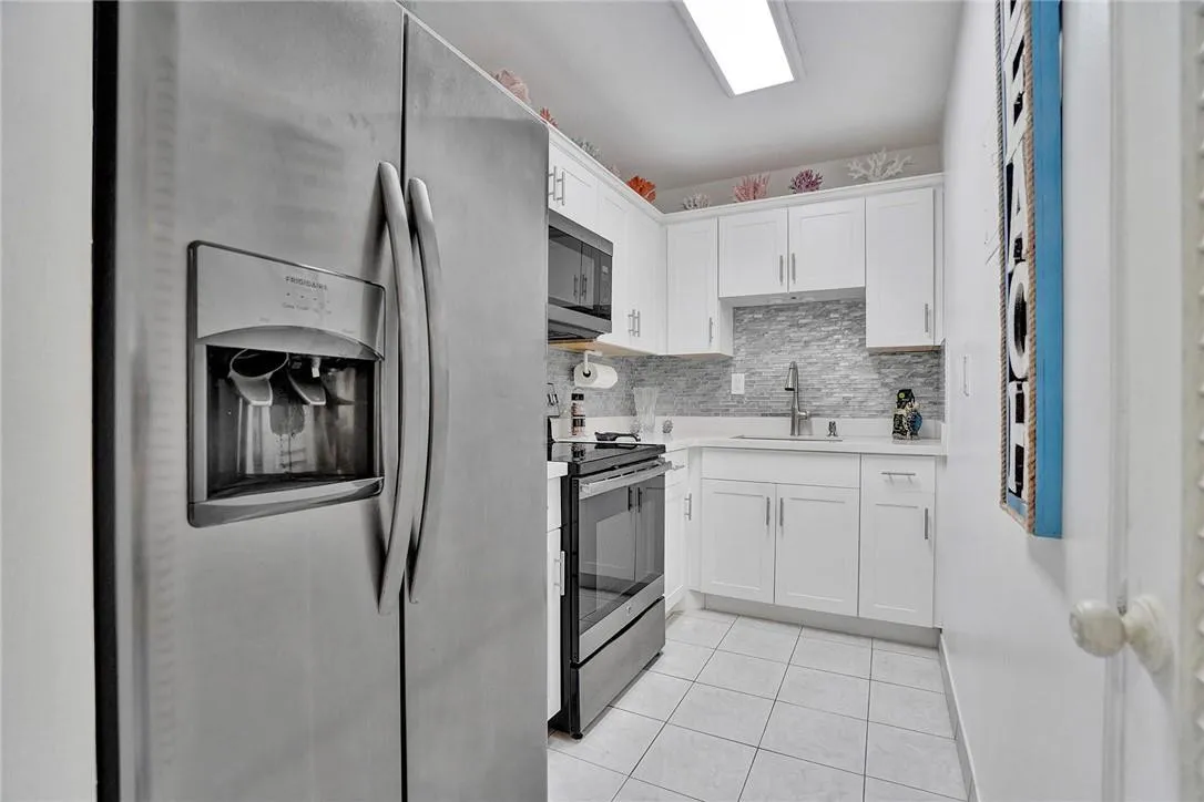 Updated Kitchen with Stainless Appliances and Glass Backsplash.