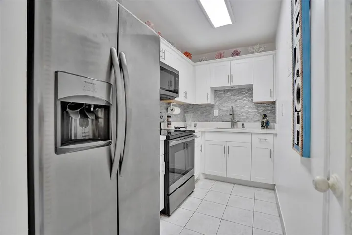 Updated Kitchen with Stainless Appliances and Glass Backsplash.