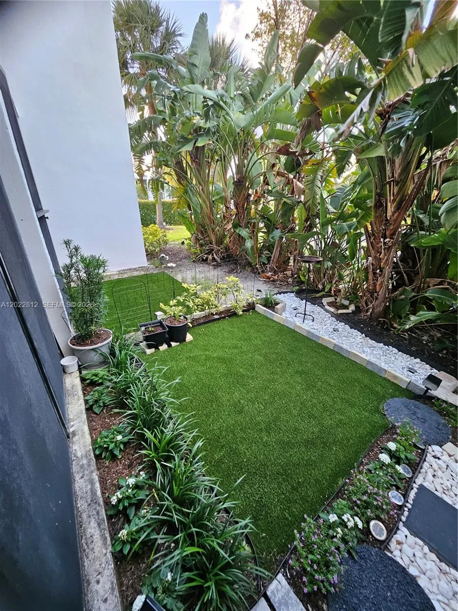 Beautifully landscaped backyard featuring low-maintenance artificial turf and a serene garden-style setting — perfect for relaxing or entertaining.