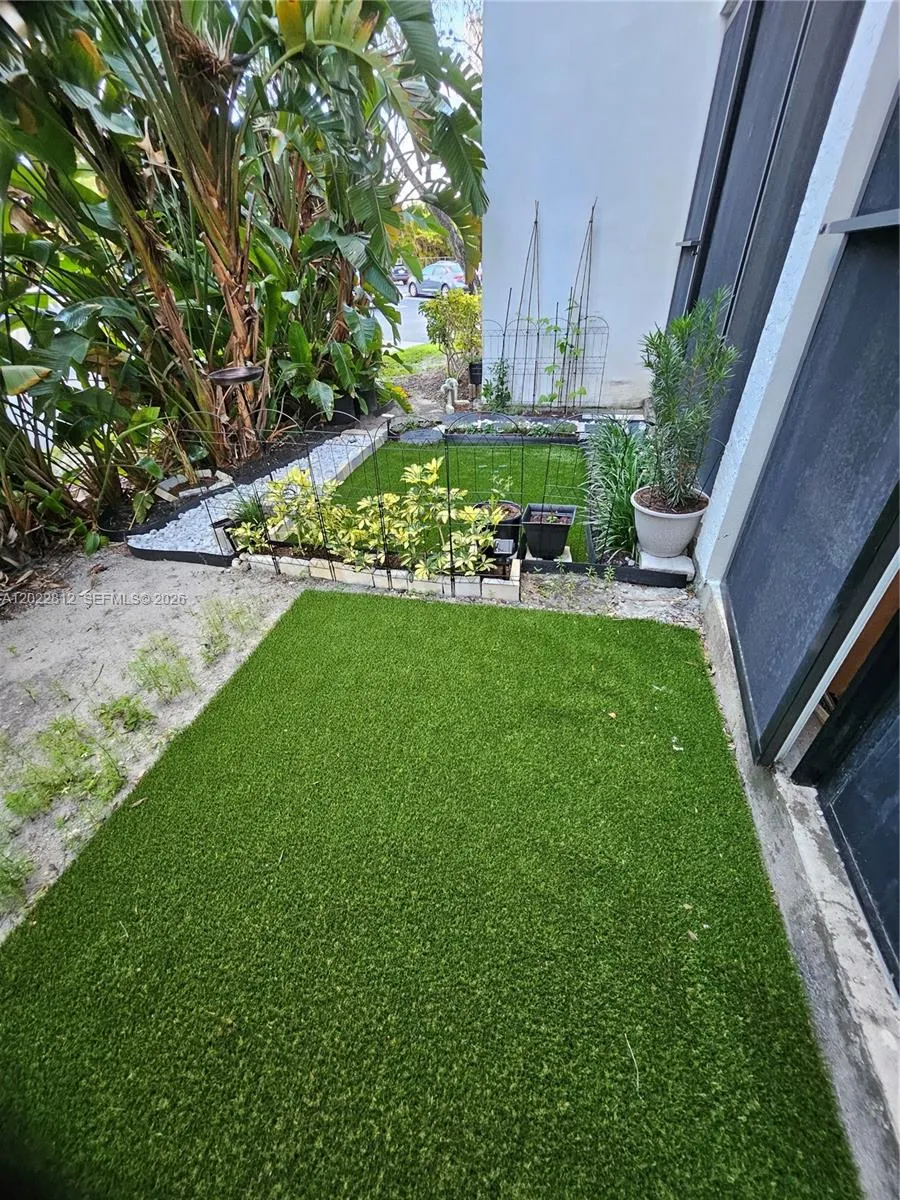 Beautifully landscaped backyard featuring low-maintenance artificial turf and a serene garden-style setting — perfect for relaxing or entertaining.