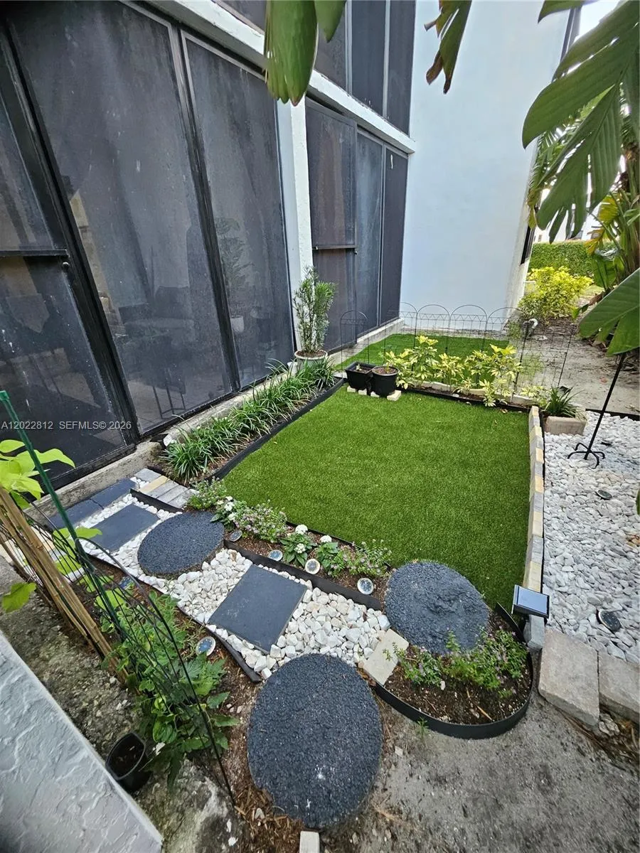 Beautifully landscaped backyard featuring low-maintenance artificial turf and a serene garden-style setting — perfect for relaxing or entertaining.