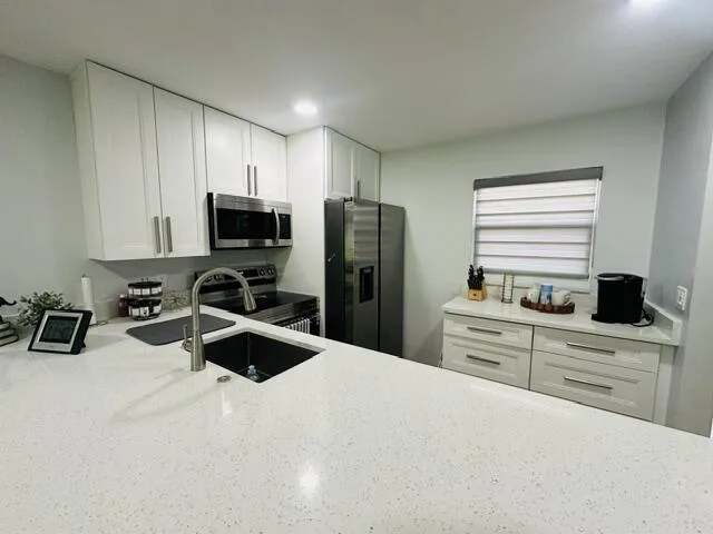 Coffee station set up in the kitchen Ceiling with recessed lighting, bright beautiful blinds throughout the unit