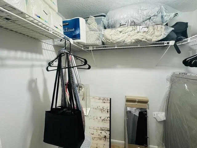 walk in closet plus custom closets against the bedroom wall