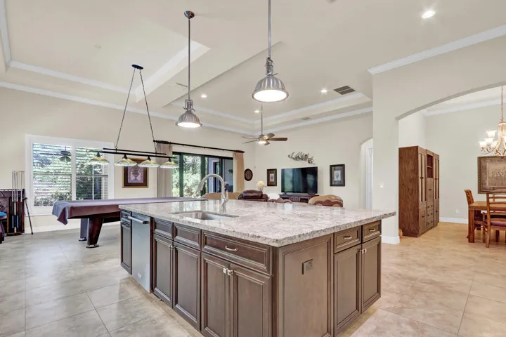 View from the island to the informal and formal dining rooms, living space, and back patio
