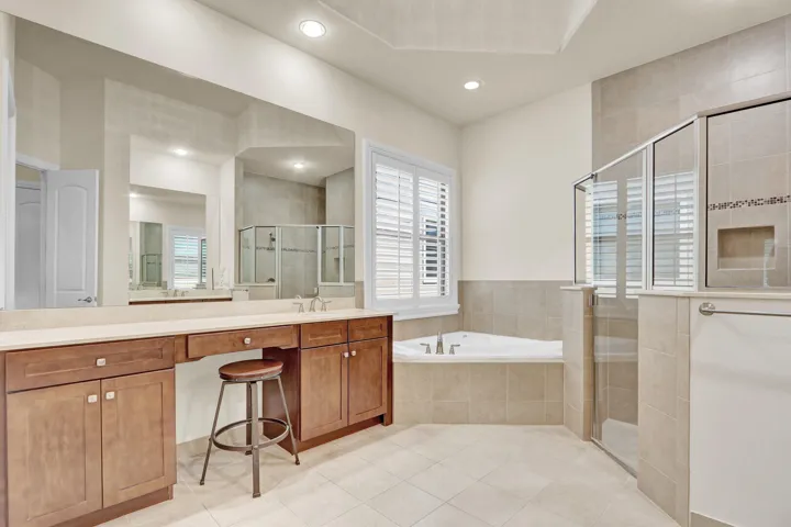 Masterbathroom has a his and hers vanity, a soaking tub, and a large walk-in shower, plus a linen closet and doored private toilet.