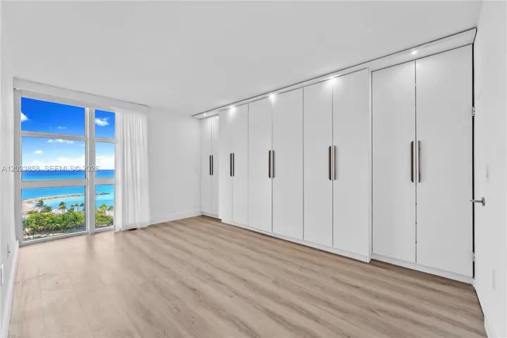Can easily fit a King or California King size bed. Custom wardrobe closet can be removed.